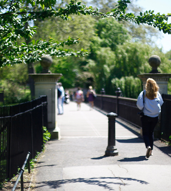 People walking through public park across bridge